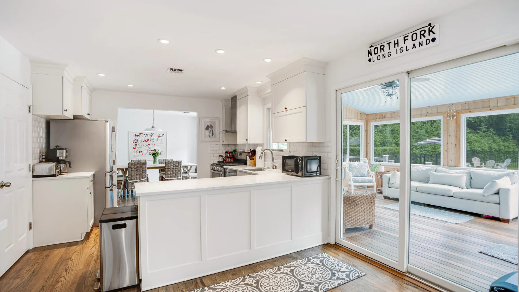 A bright kitchen opens through sliding glass doors to a patio with seating.
