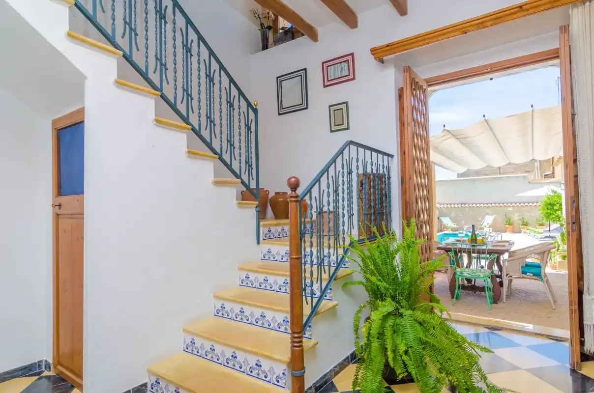 A tiled staircase and landing open onto a bright outdoor dining area.