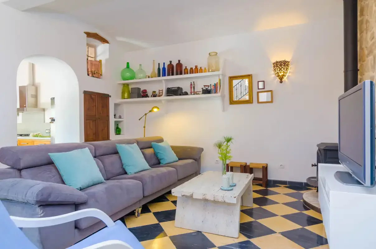 A living room with seating, a coffee table, and a television.