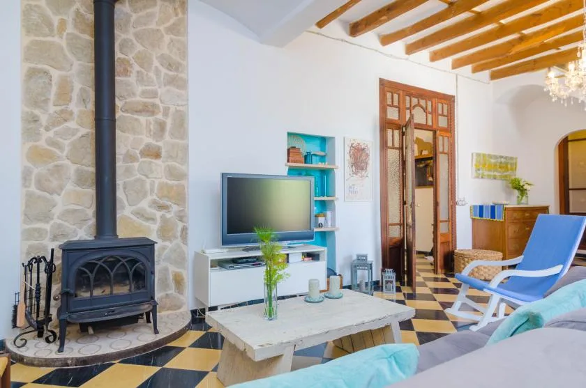 A bright living room with a stone fireplace, television, and seating.