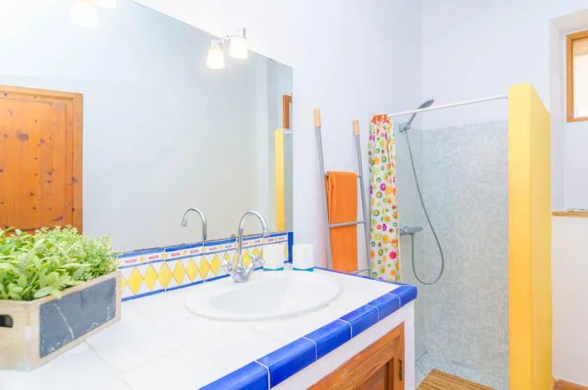 A bathroom vanity with a sink stands beside an open shower area.