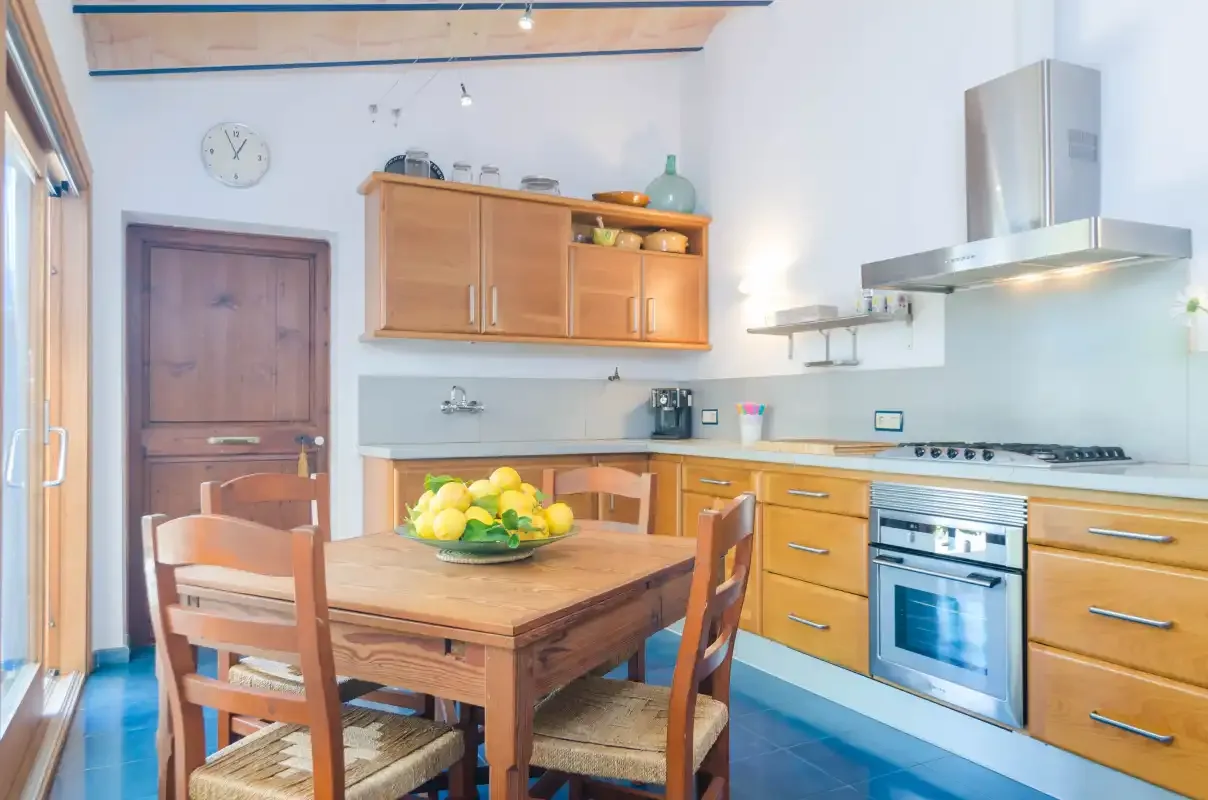 A bright kitchen with wooden cabinets, a dining table, and cooking appliances.
