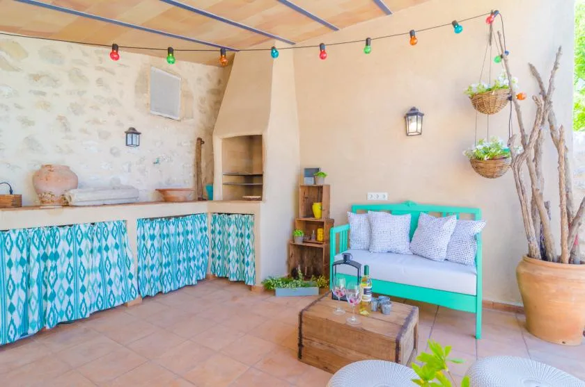 A colorful patio seating area with a tiled counter and a turquoise bench.