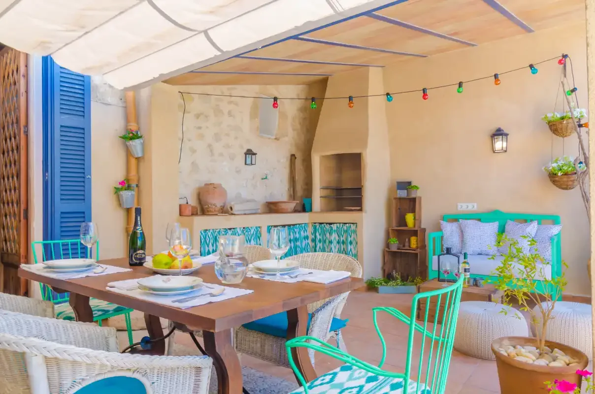 A colorful patio dining area has a wooden table and turquoise seating.