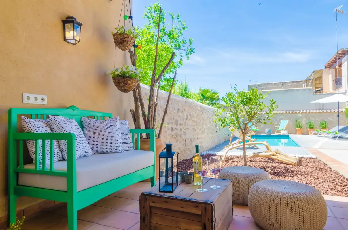 A patio seating area overlooks a swimming pool and landscaped courtyard.