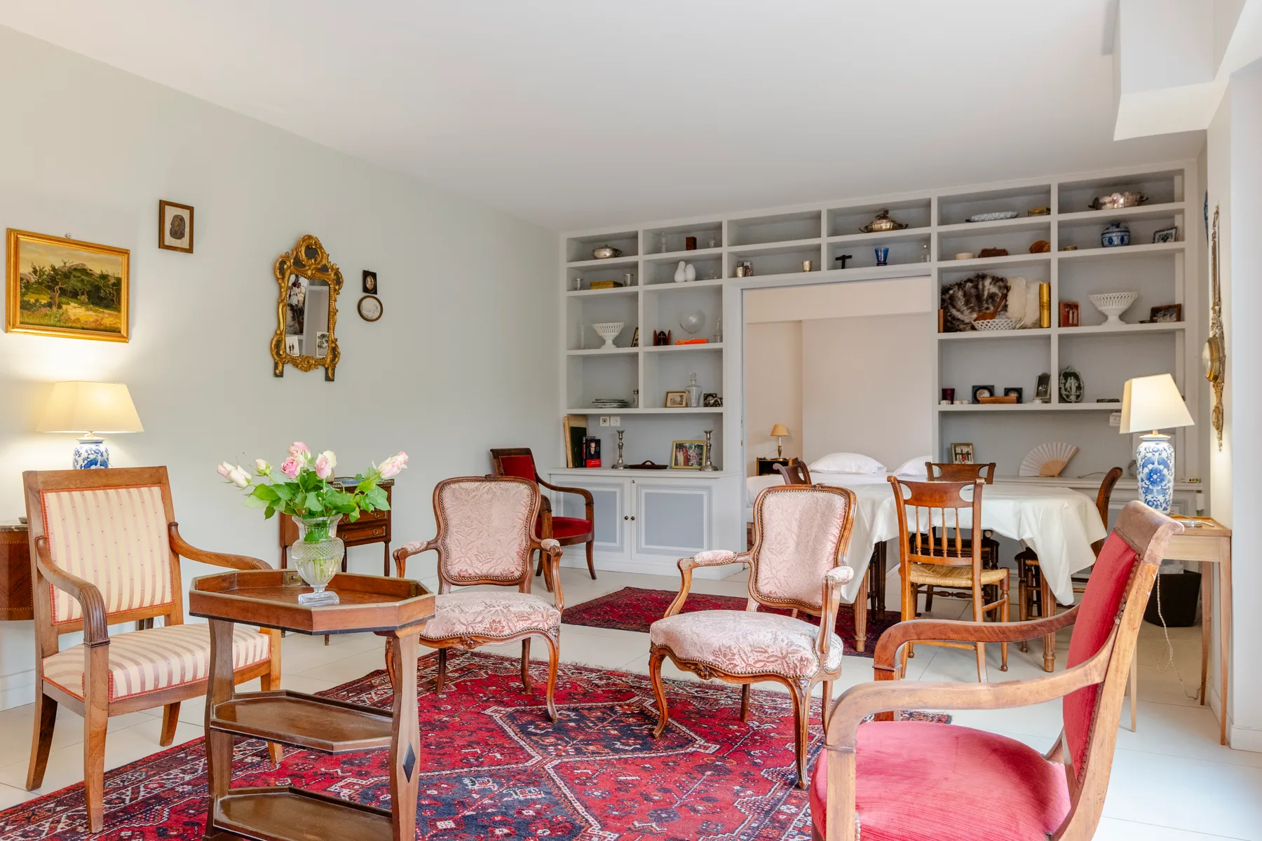 A sitting room with upholstered seating, wooden tables, and a patterned rug.