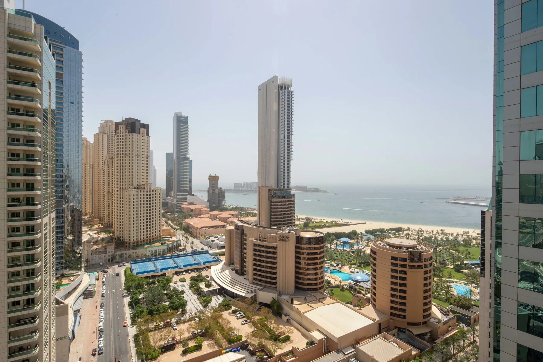 Un horizonte urbano costero con edificios altos, calles y el mar al fondo.