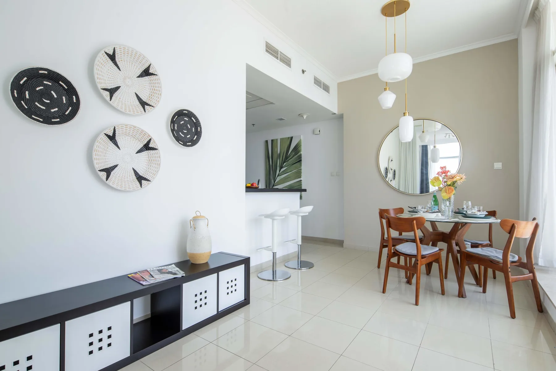 Un comedor luminoso con una mesa de madera y adornos en la pared.
