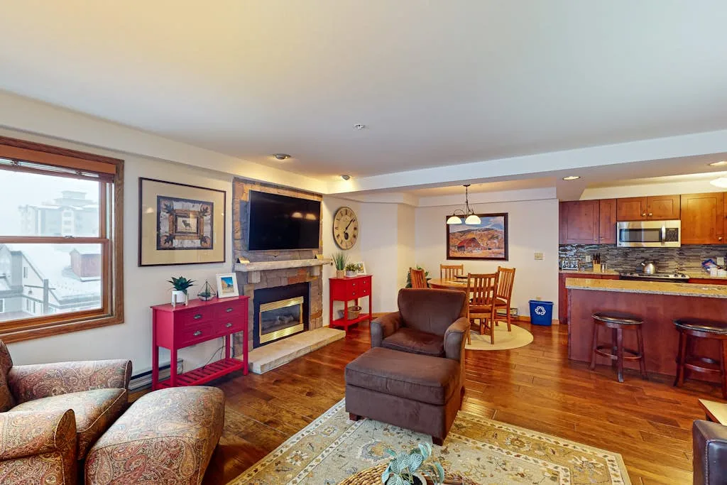 Una sala de estar con asientos, televisor y chimenea.