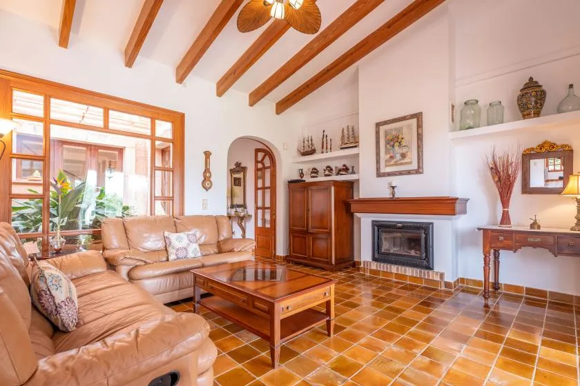 A living room with leather seating, a wooden coffee table, and a fireplace.