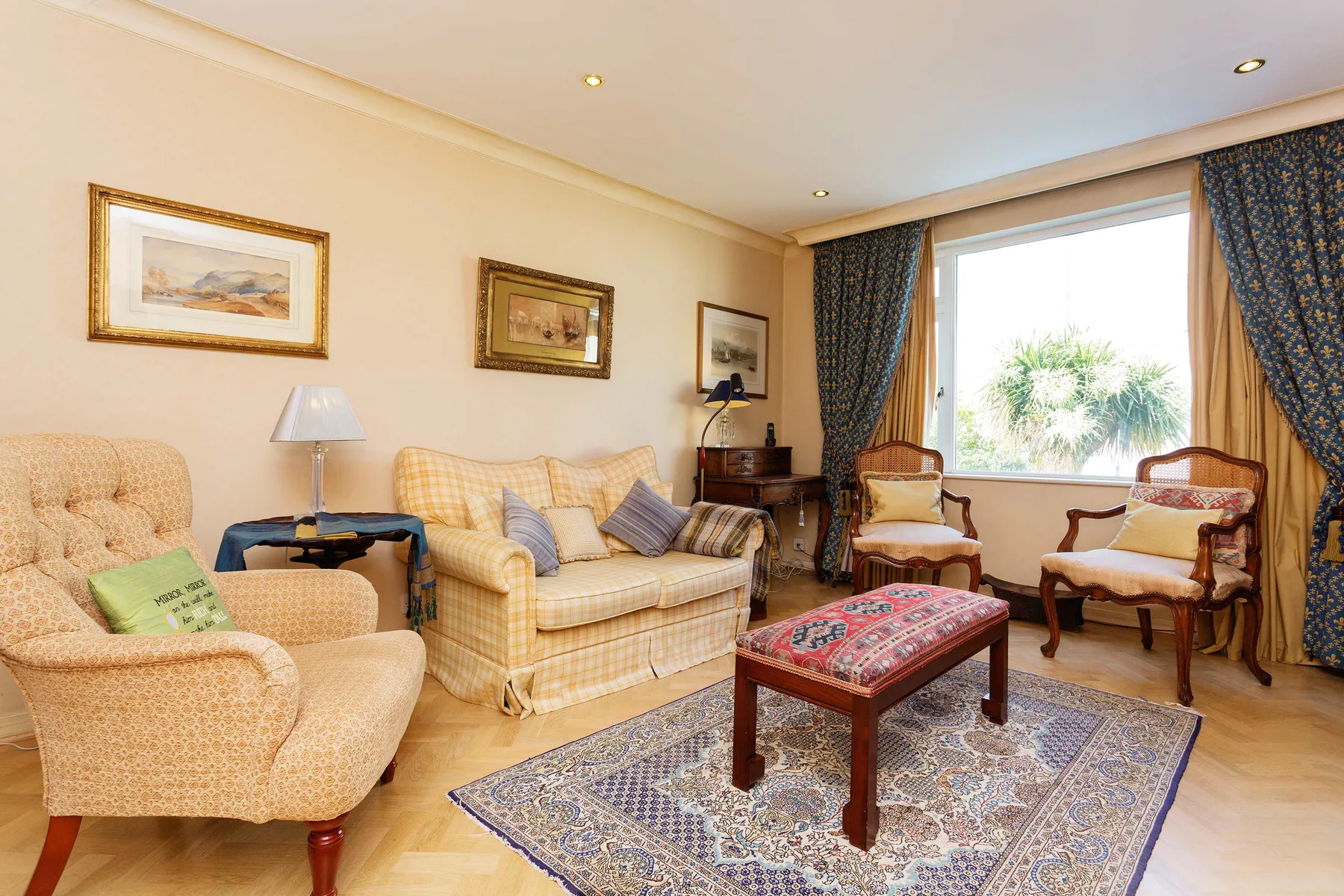 A living room with upholstered seating, a patterned rug, and a coffee table.