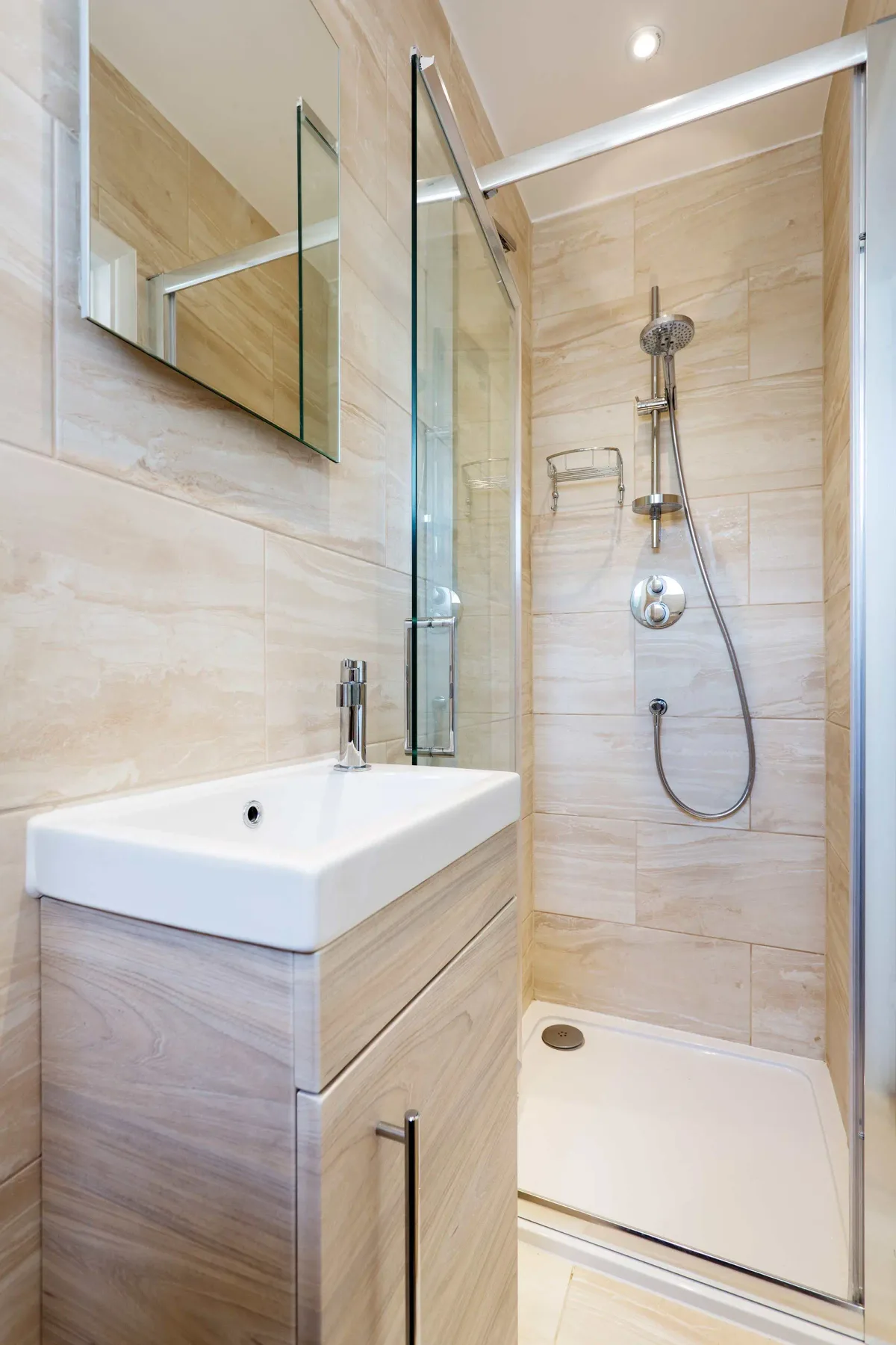 A bathroom with a vanity sink and a glass-enclosed shower.