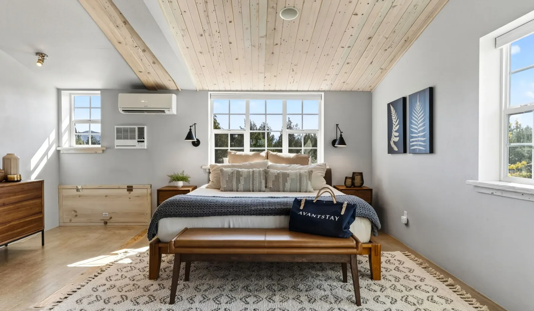 Un dormitorio luminoso con una cama bajo un techo inclinado de madera.