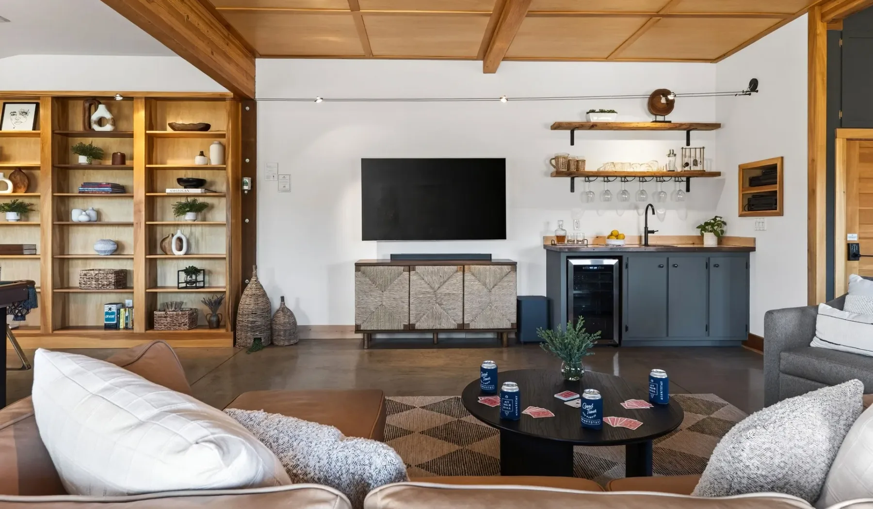 Sala de estar con asientos alrededor de una mesa de centro y un televisor.