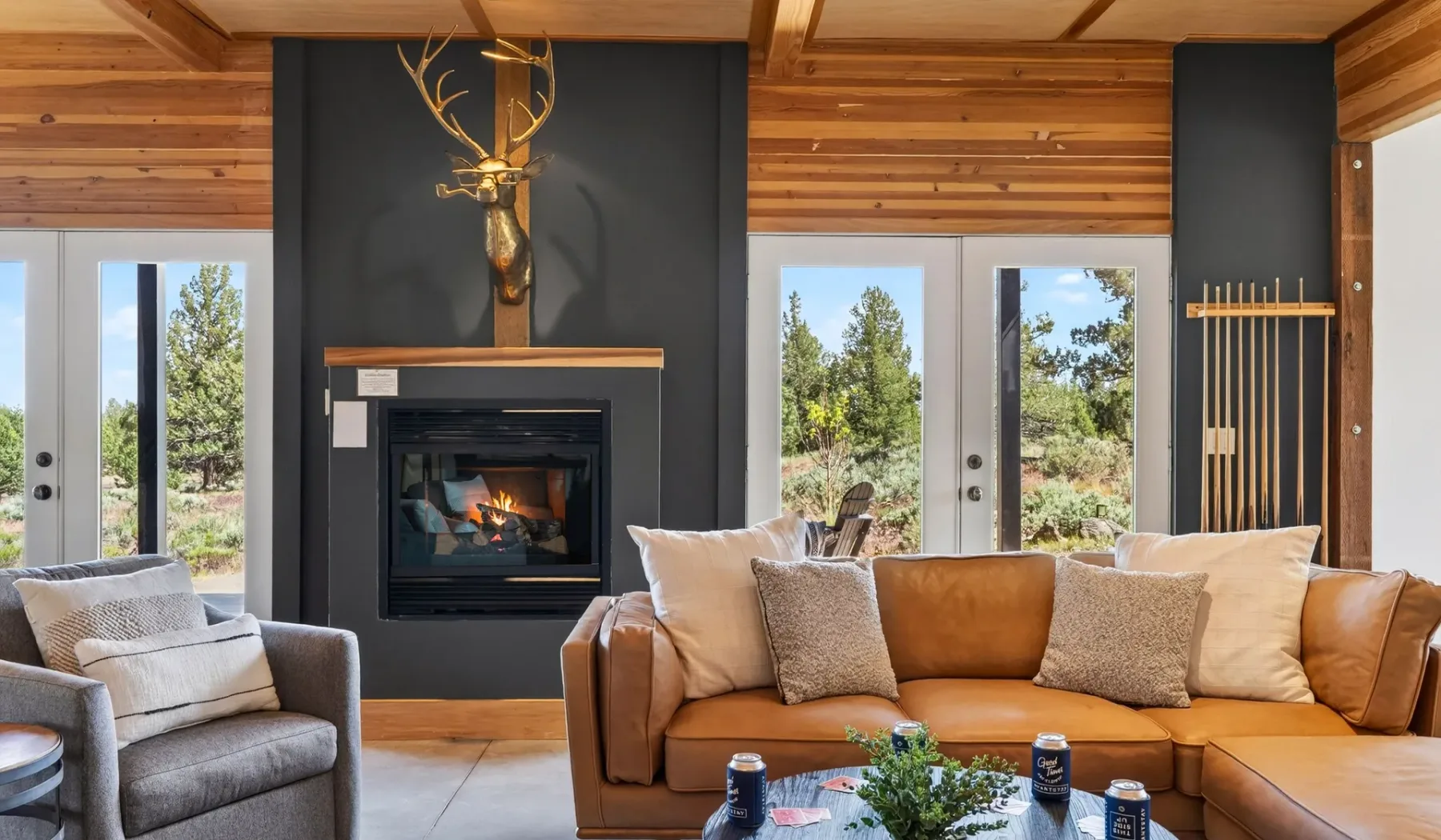 Sala de estar revestida de madera con asientos alrededor de una chimenea.