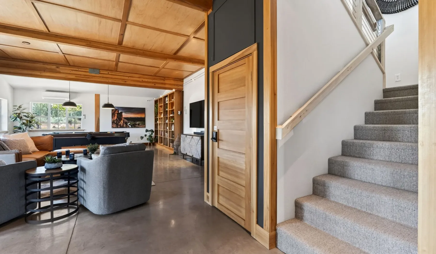 Una sala de estar con asientos, una mesa de centro y una escalera al lado.