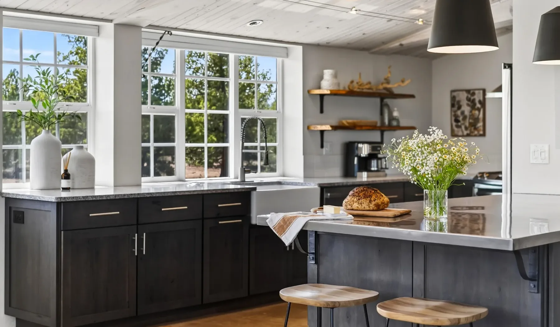 Una cocina luminosa con gabinetes oscuros, ventanas grandes y una isla central.