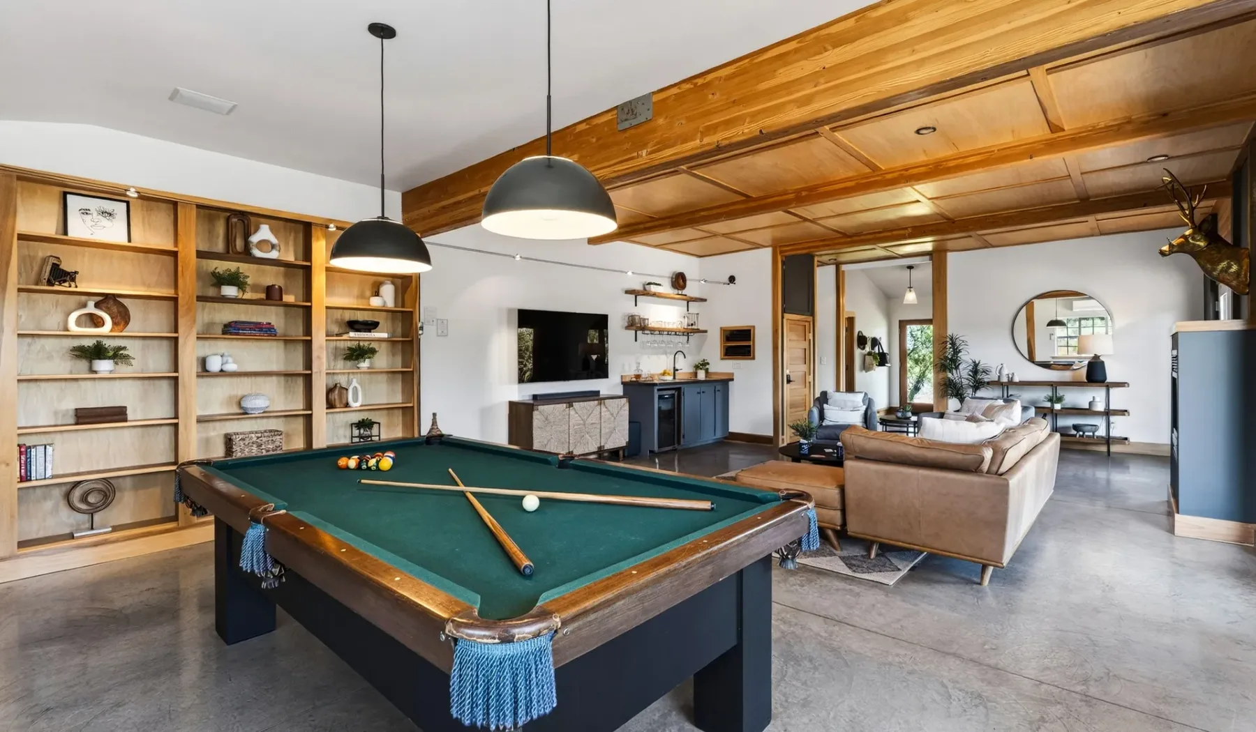 Una sala de juegos con mesa de billar y zona de estar abierta.