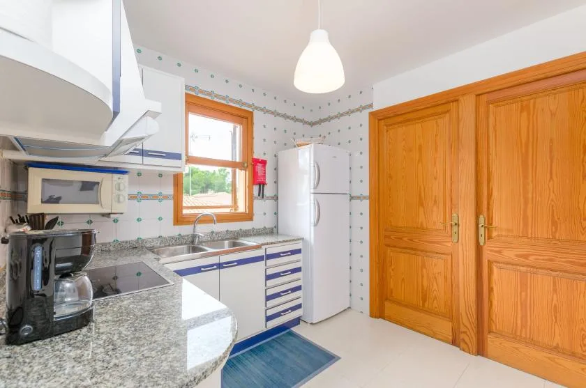 A kitchen with a countertop, appliances, and wooden cabinets.