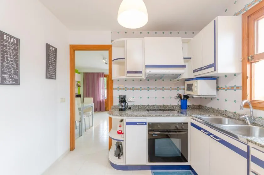 A bright kitchen with white cabinetry, a countertop, and a sink.