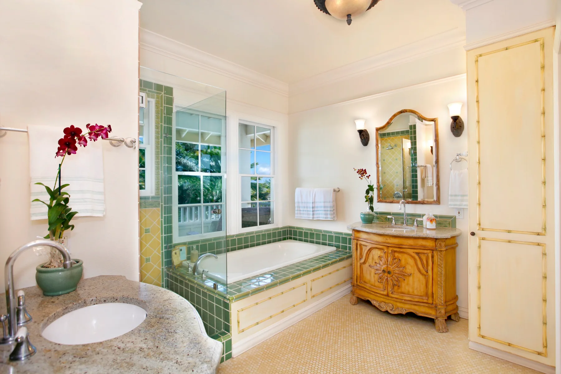 A bright bathroom with a bathtub, vanity, and tiled shower area.