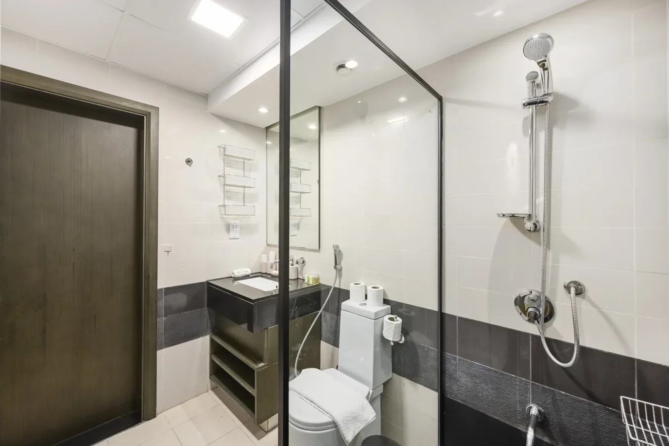 A tiled bathroom with a glass shower screen and toilet.