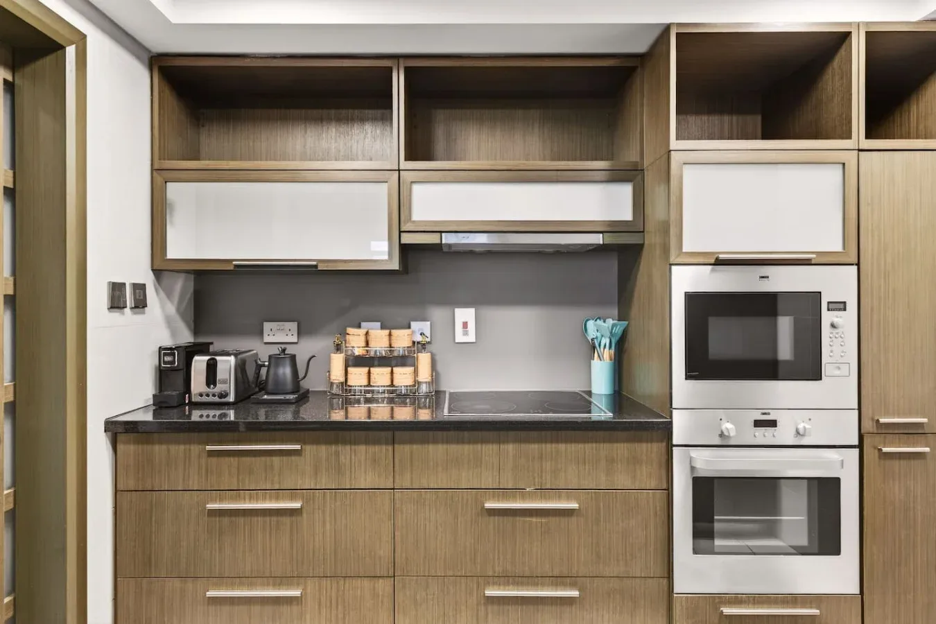 A modern kitchen with wood cabinetry, a countertop, and built-in appliances.