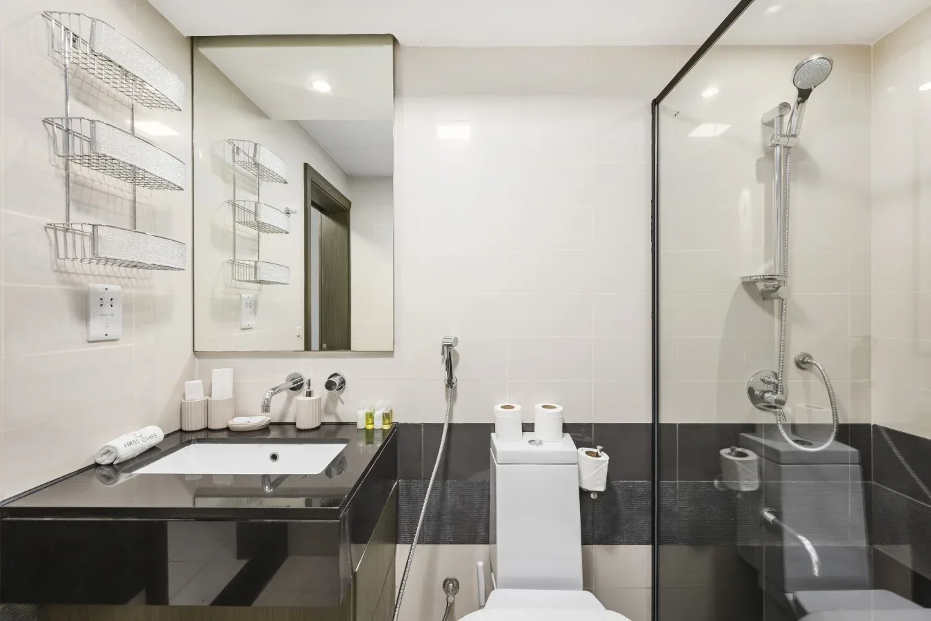 A modern bathroom with a sink, mirror, and glass-enclosed shower.