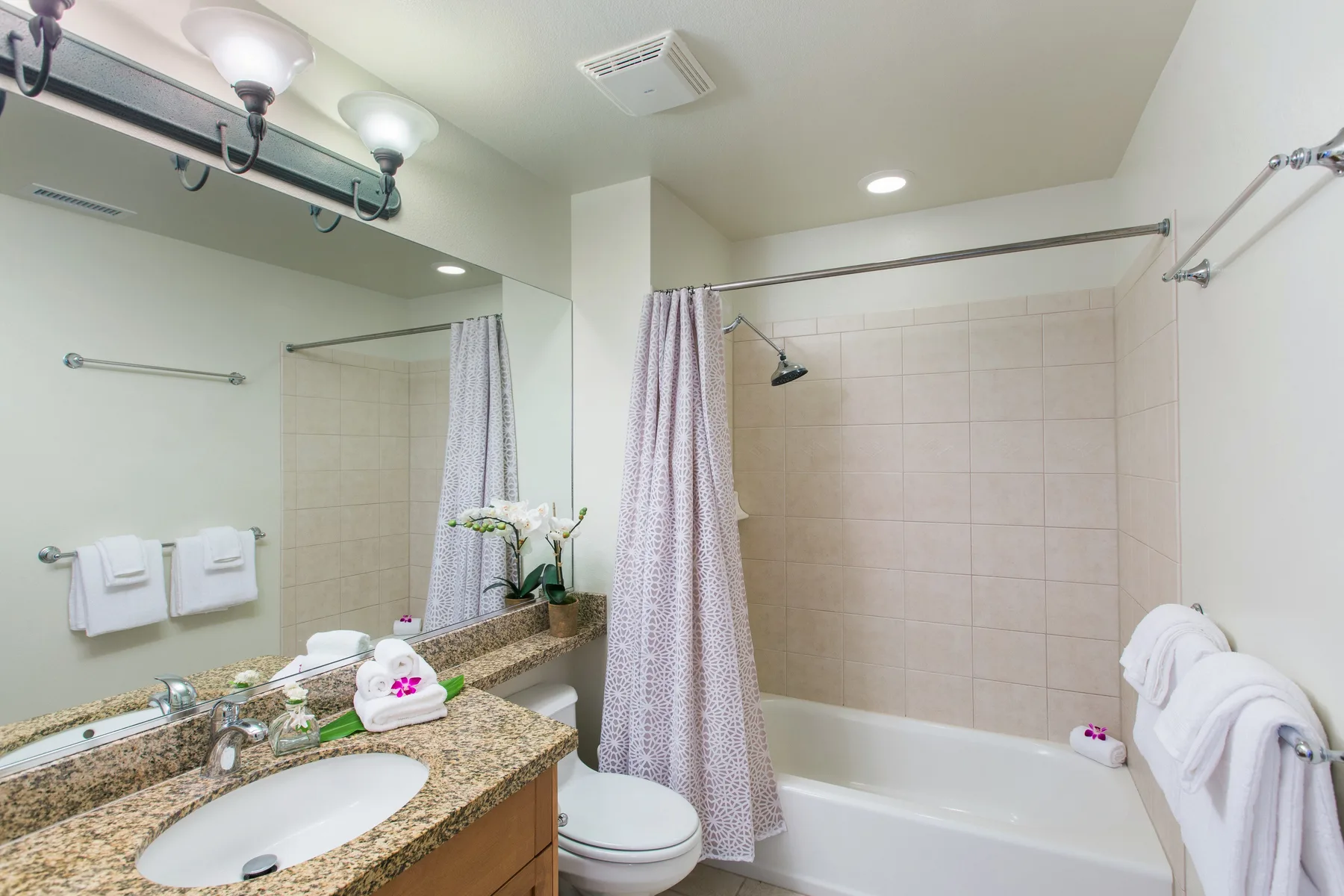 A bathroom with a bathtub, shower, and vanity.