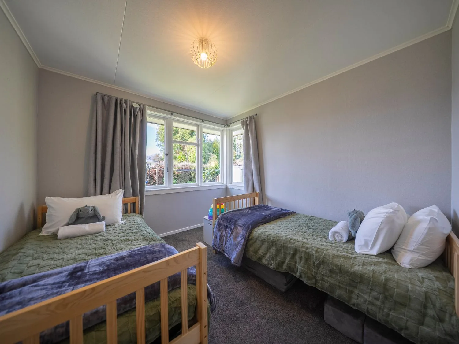 Un dormitorio con dos camas individuales y una ventana en Quiet on Quintin - Te Anau Holiday Home, Te Anau