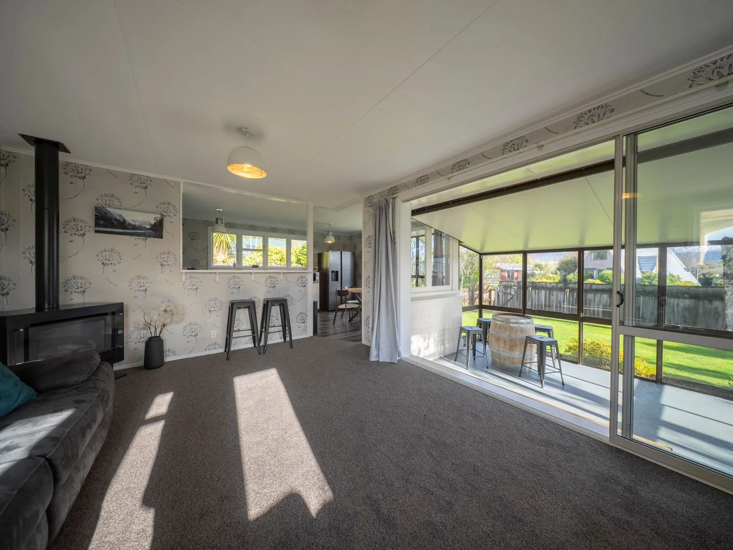 Una sala de estar con sofá y chimenea en Quiet on Quintin - Te Anau Holiday Home, en Te Anau