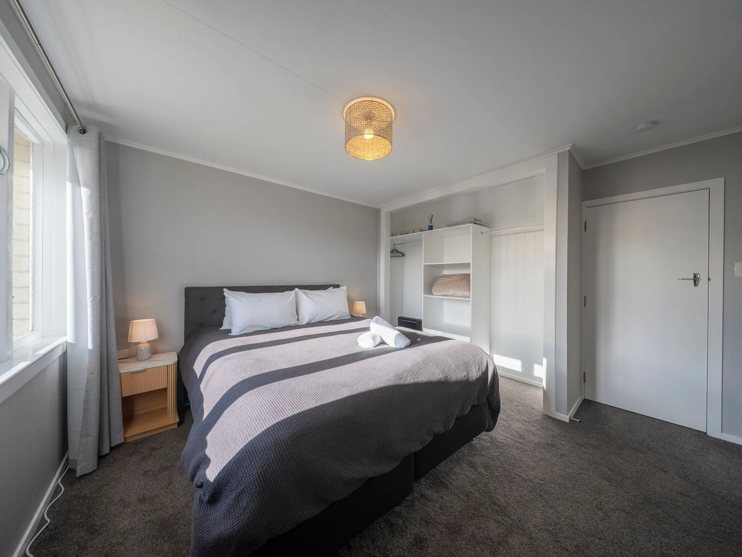 Un dormitorio con cama y mesa de noche en Quiet on Quintin - Te Anau Holiday Home, Te Anau