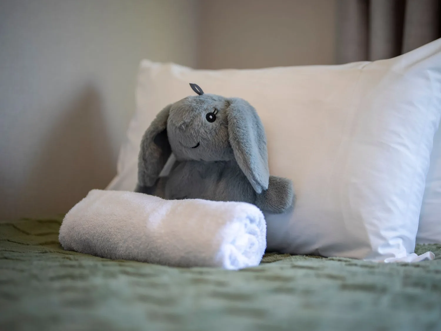 Un peluche y una toalla sobre una cama en Quiet on Quintin - Te Anau Holiday Home, Te Anau