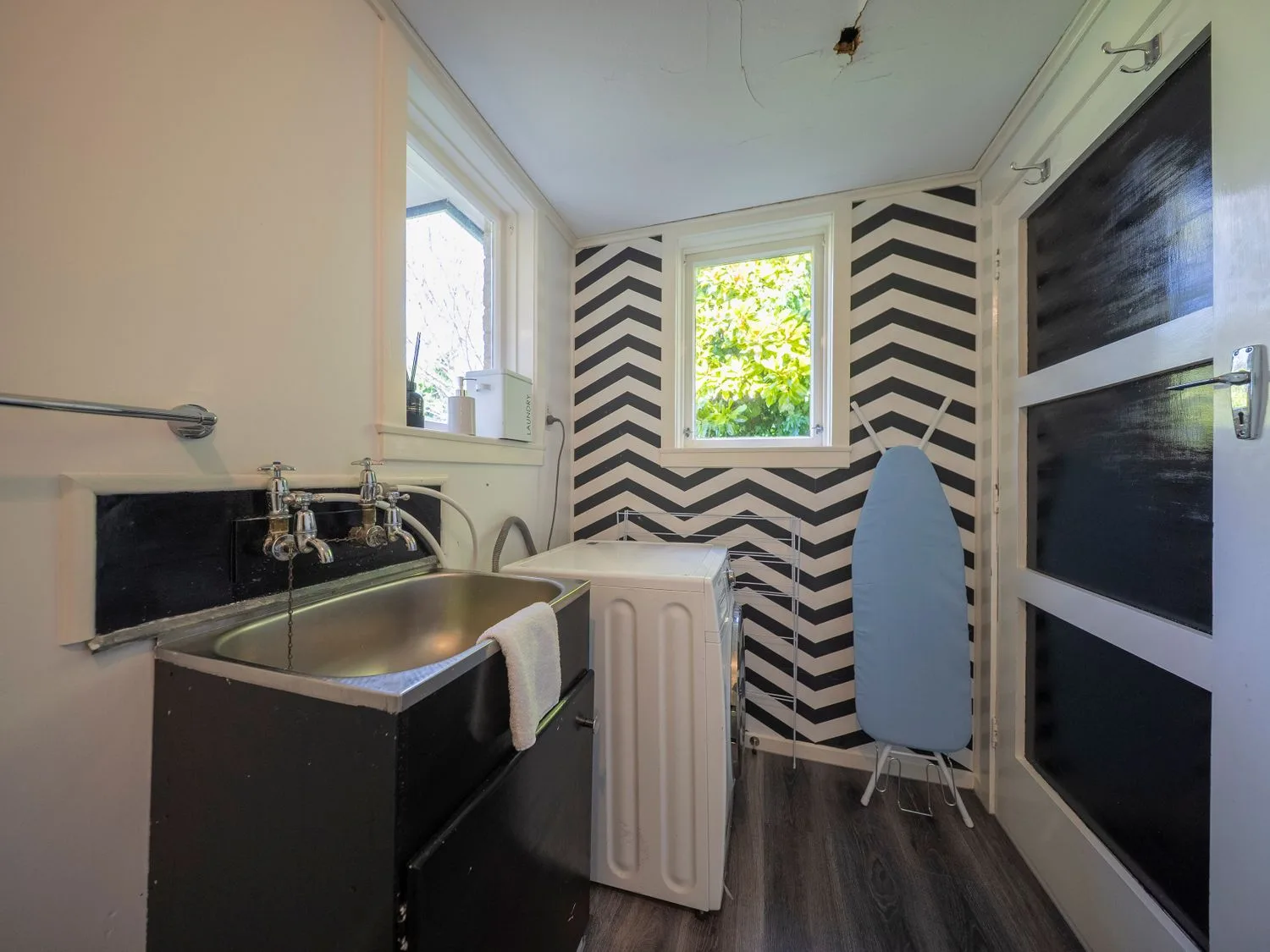 Un cuarto de lavado con fregadero y lavadora en Quiet on Quintin - Te Anau Holiday Home, Te Anau