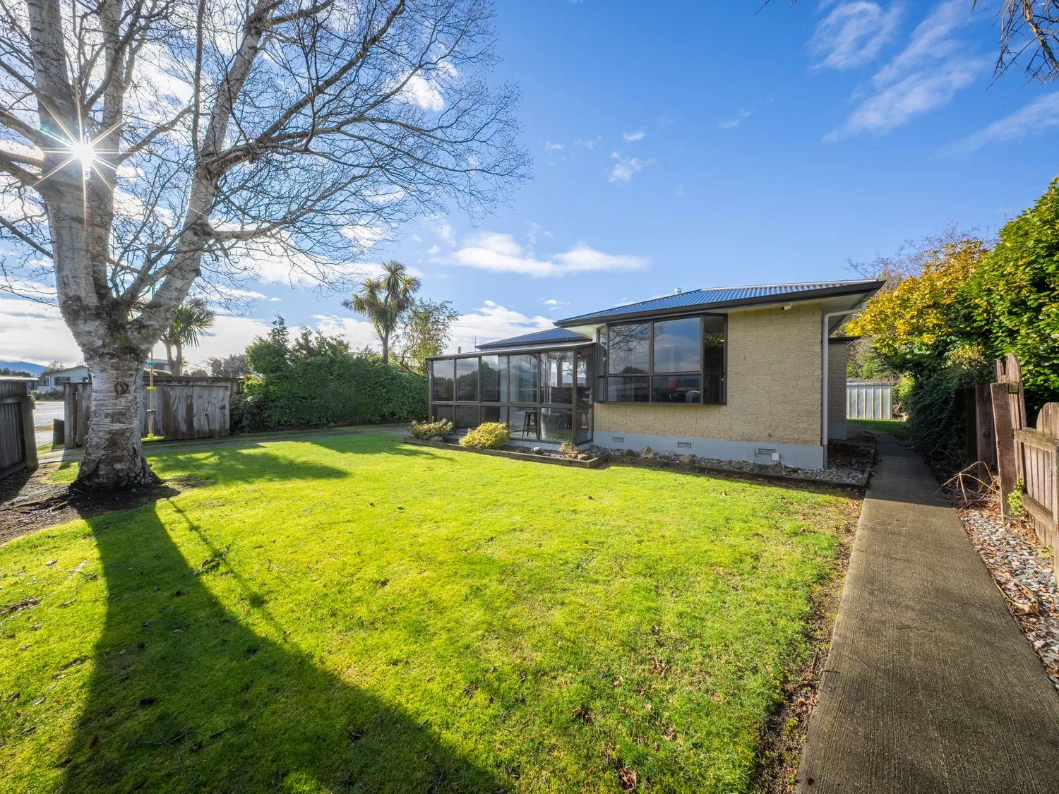 Un jardín con césped y árboles en Quiet on Quintin - Te Anau Holiday Home, Te Anau