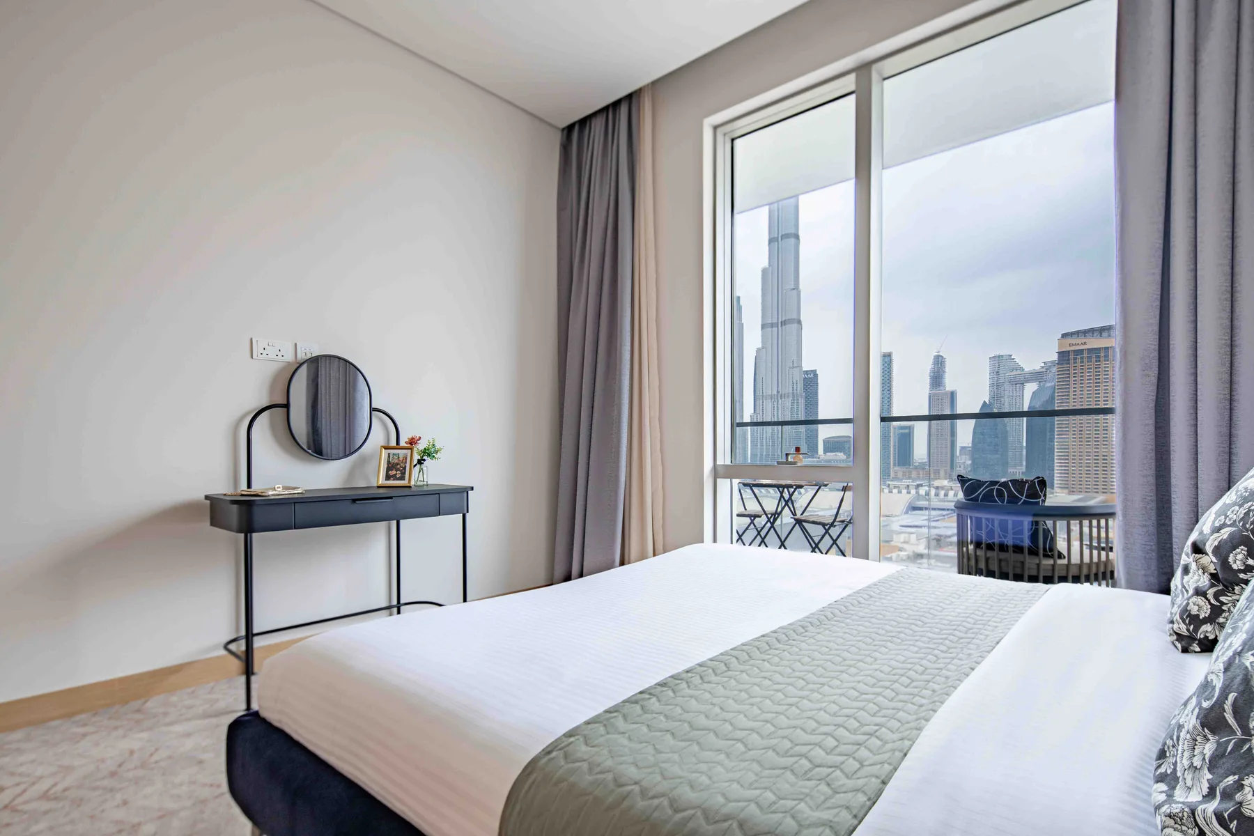 Un dormitorio con una cama y una gran ventana con vistas al horizonte urbano.