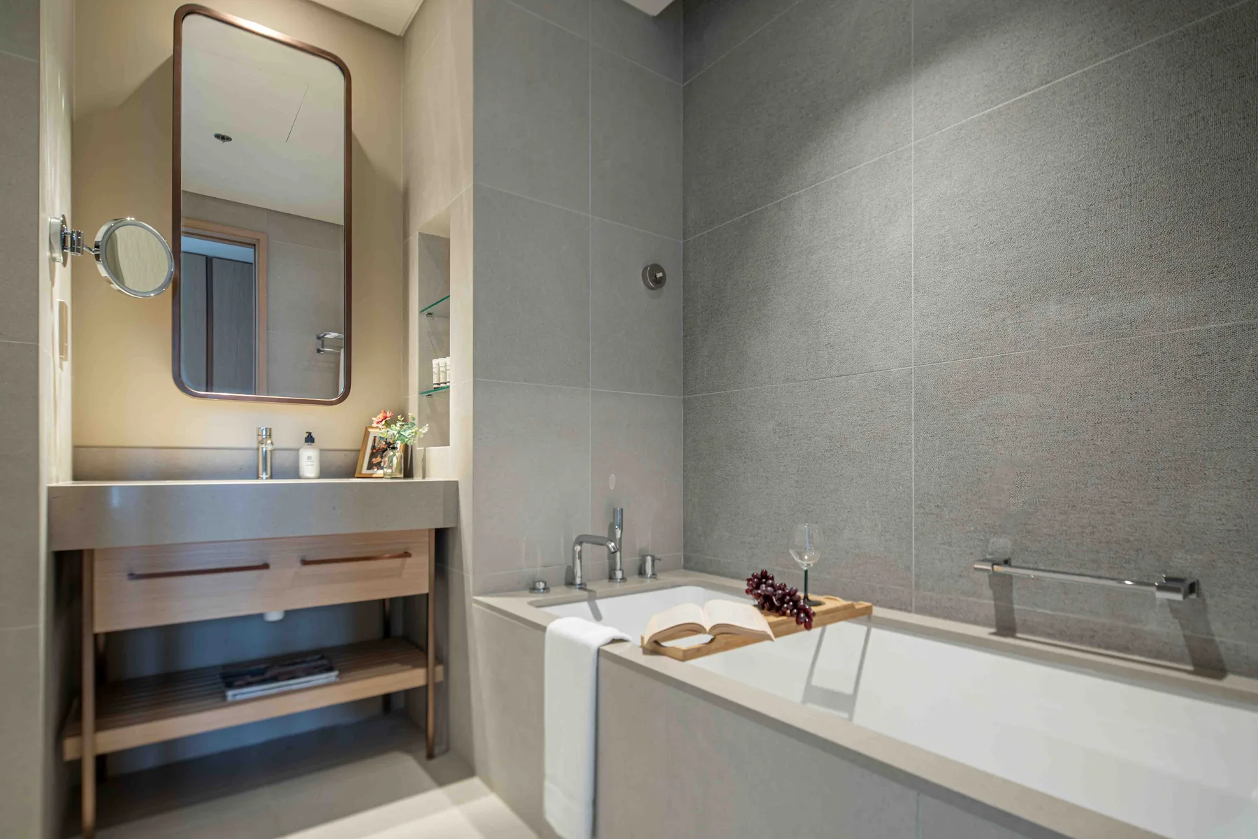 Un baño con bañera, lavabo y un espejo grande en la pared.