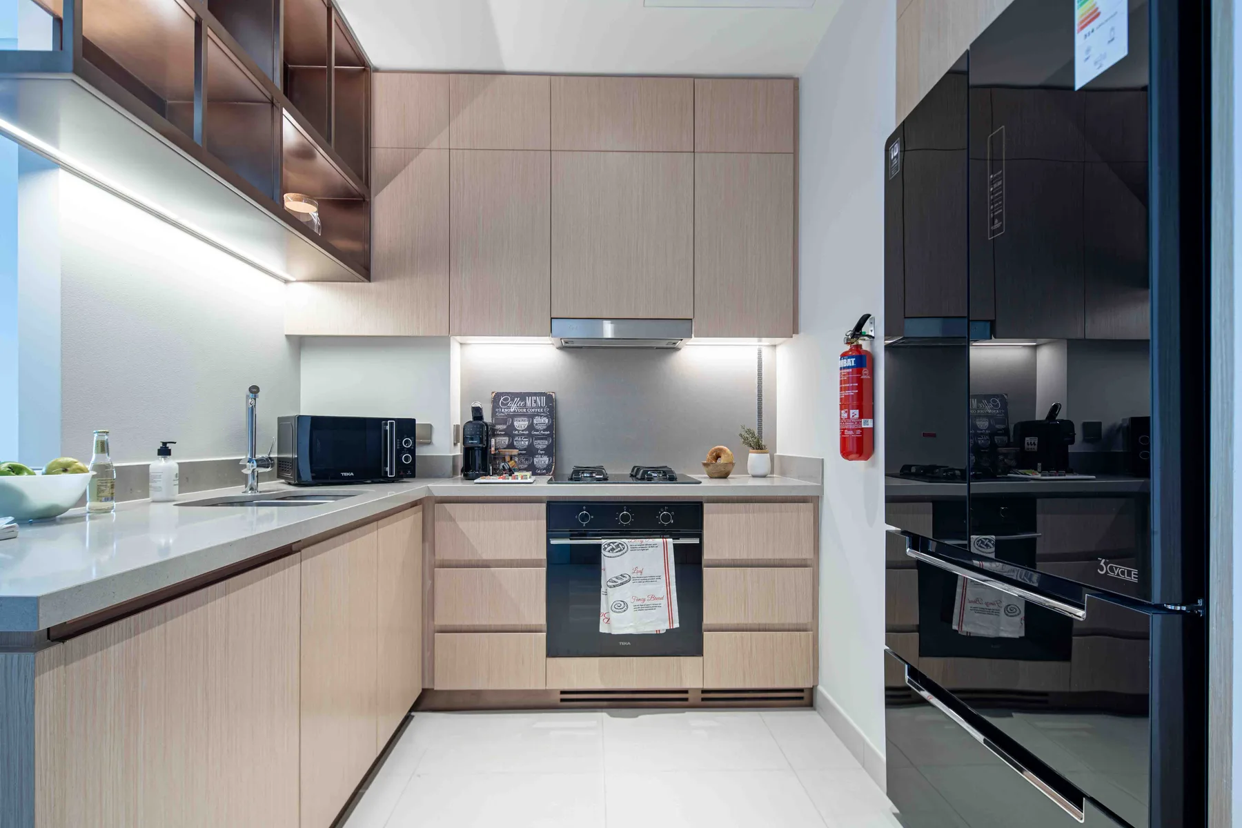 Una cocina moderna con gabinetes claros, una encimera y electrodomésticos integrados.
