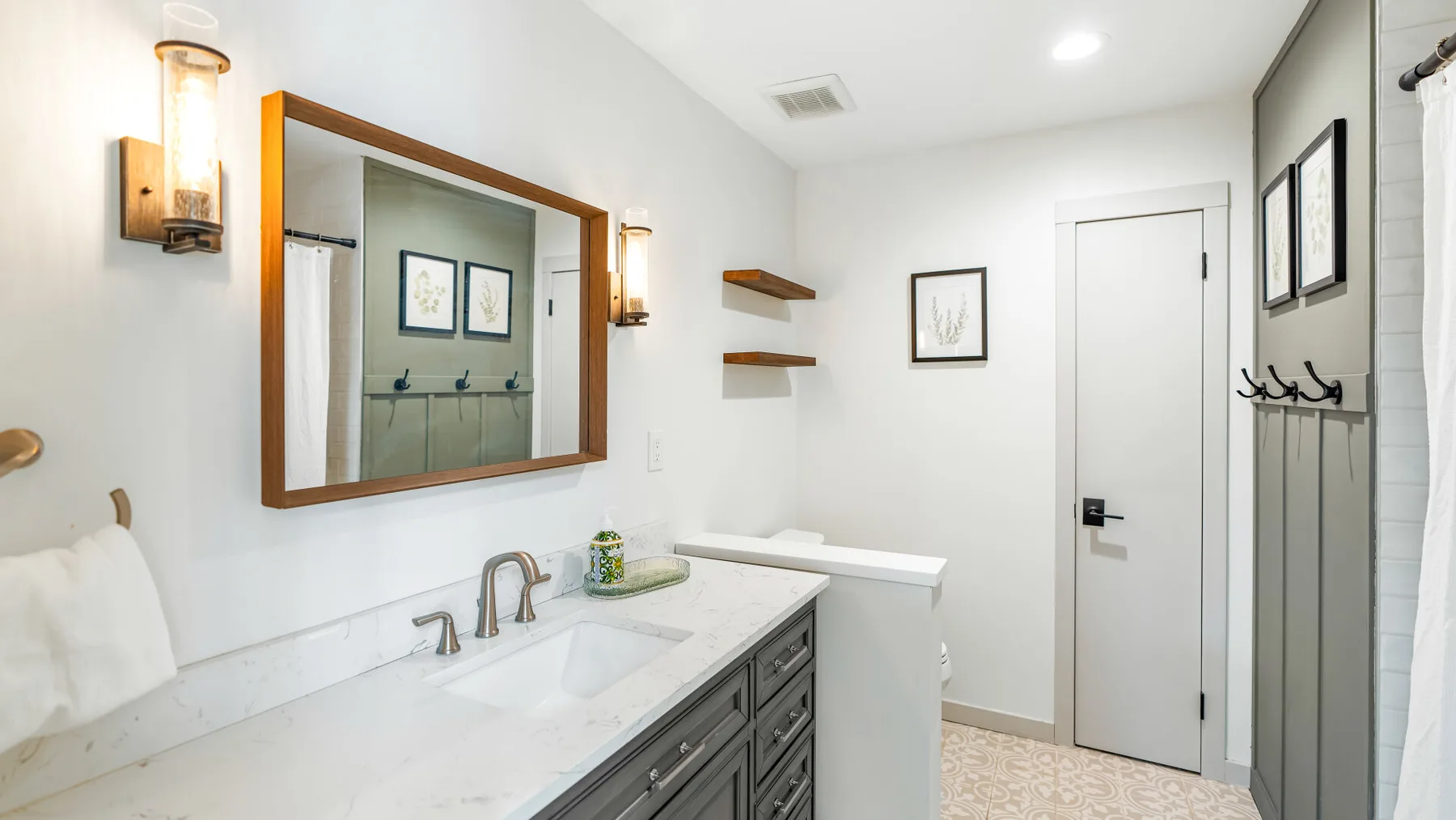 Un lavabo de baño luminoso con un espejo amplio, un lavamanos y una encimera blanca.
