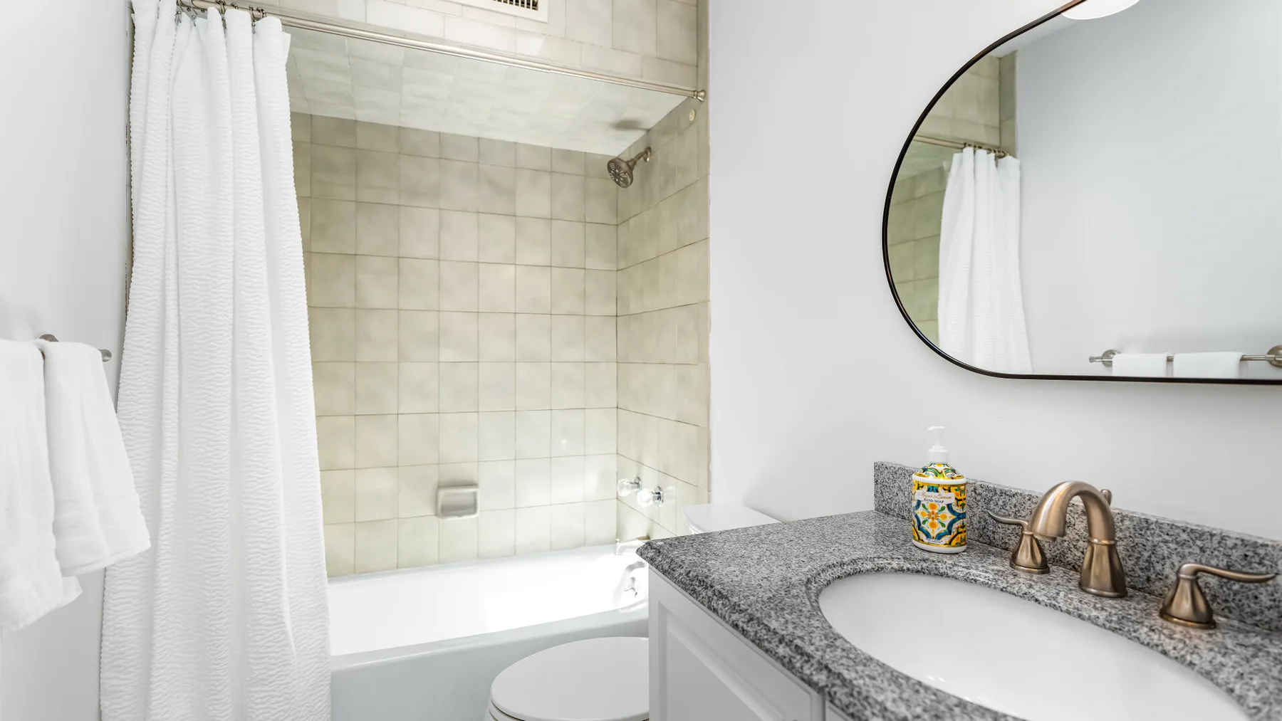Un baño con bañera, cortina de ducha y lavabo.