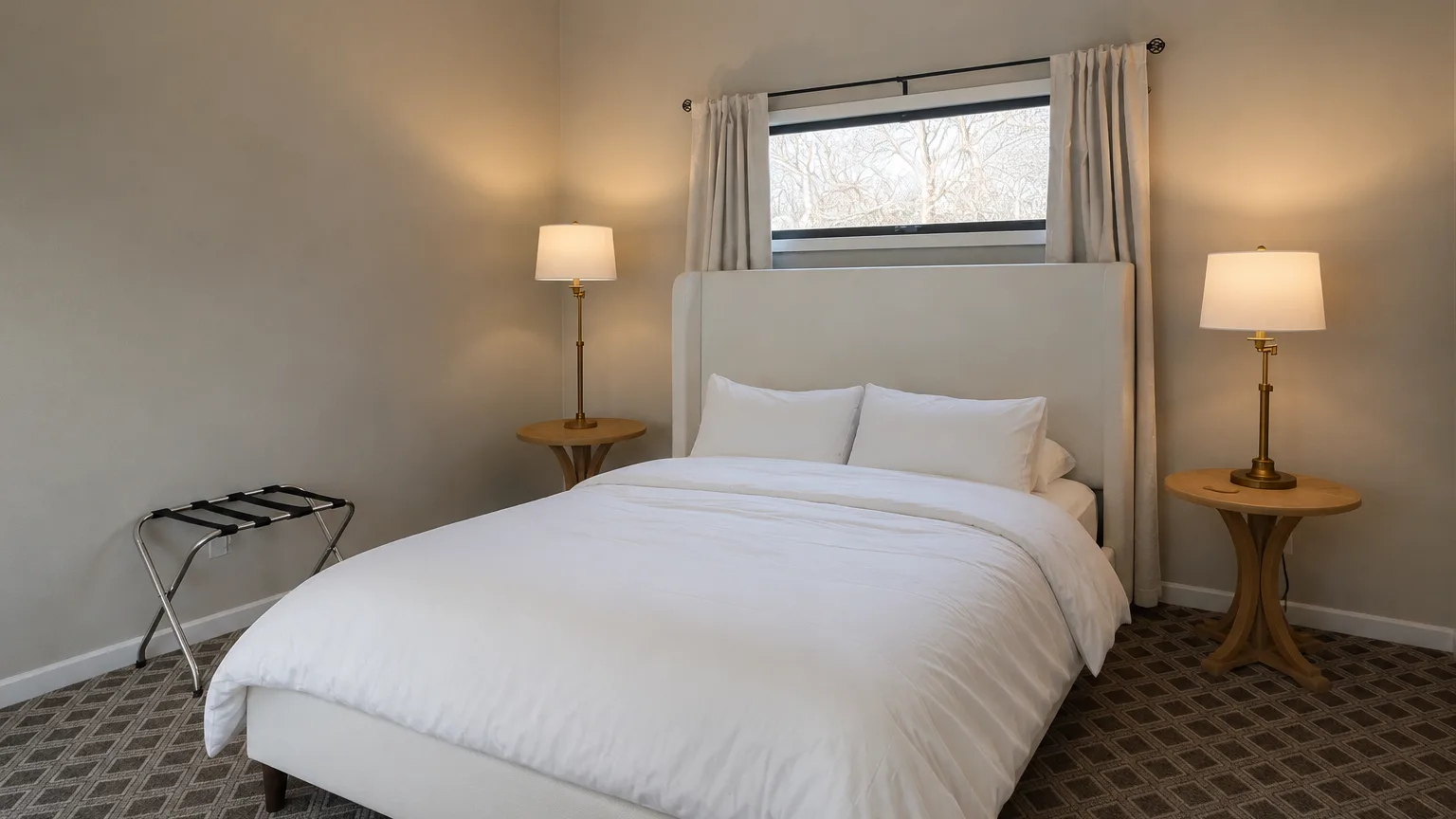 Un dormitorio con una cama bien tendida y lámparas a ambos lados.