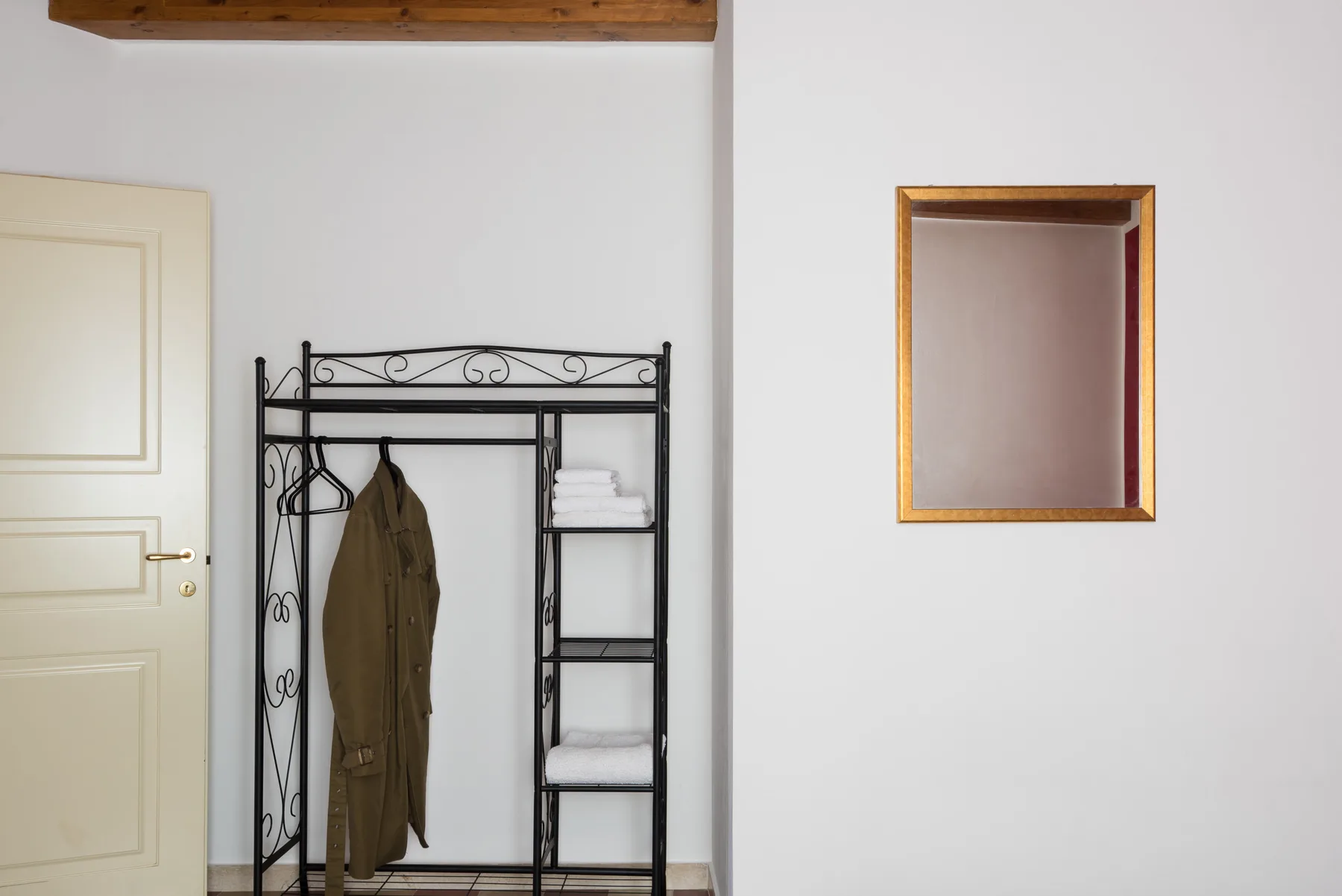 A small entry area with a coat rack and a pale door.