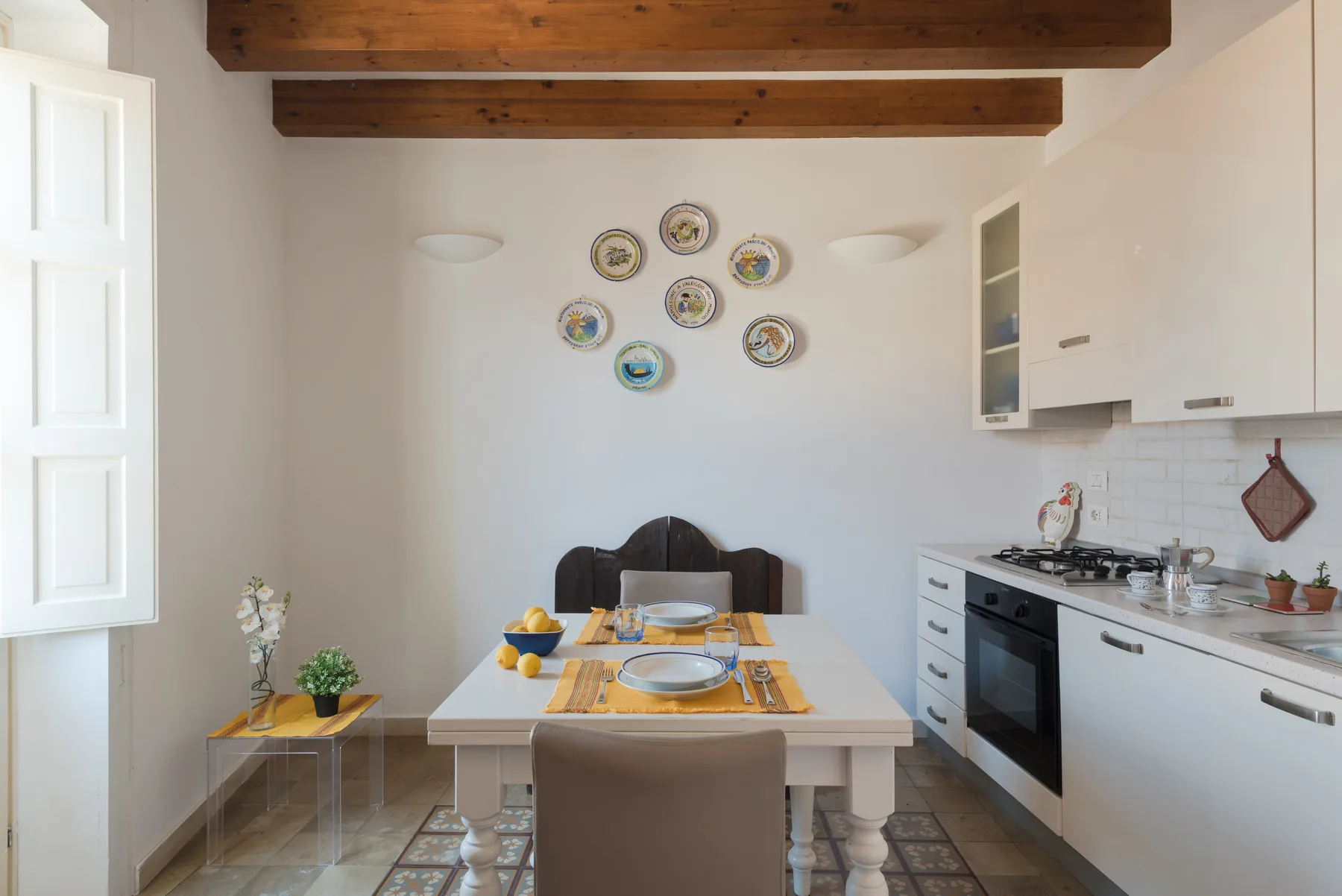 A bright dining area with a set table beside a kitchen.