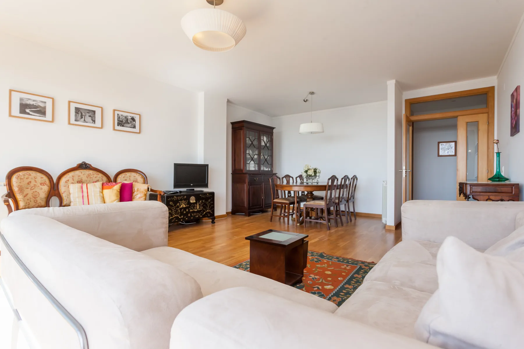 Una sala de estar con asientos, un televisor y un comedor.