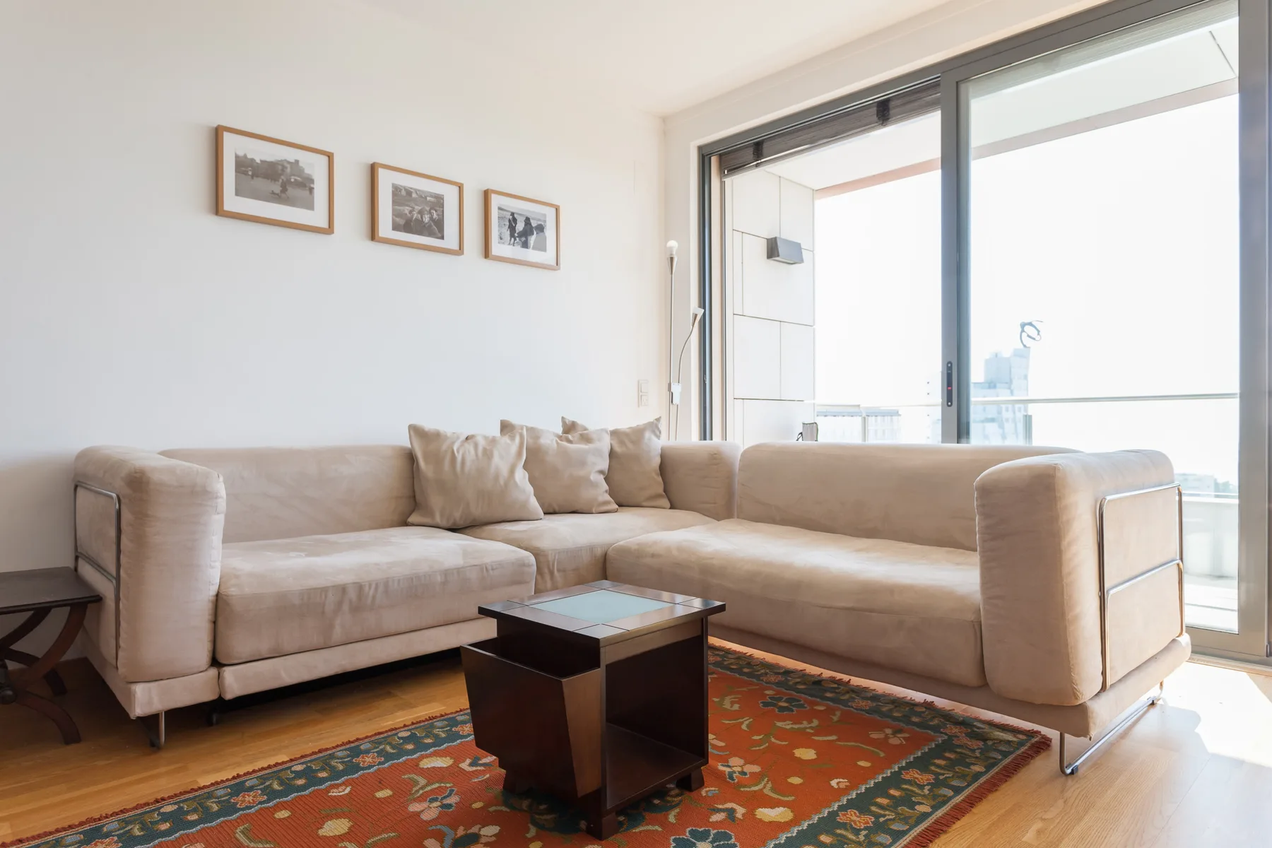 Una sala luminosa con una amplia zona de asientos y una puerta corrediza de vidrio.