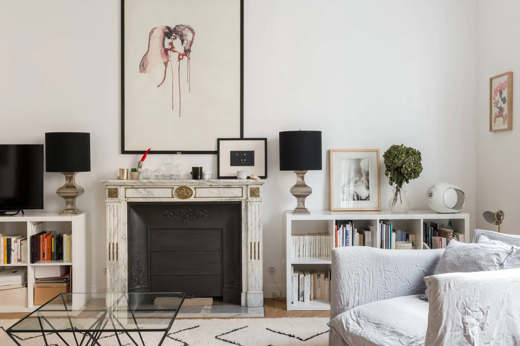A living room with a fireplace, bookshelves, and seating.