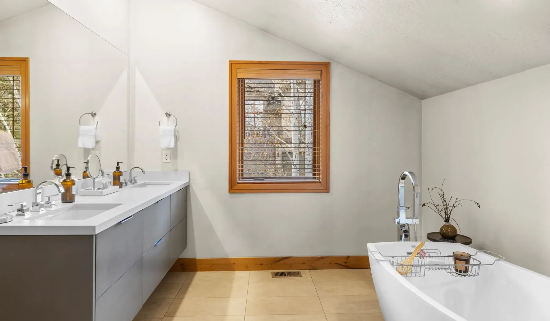 Un baño luminoso con lavabo, ventana y bañera.