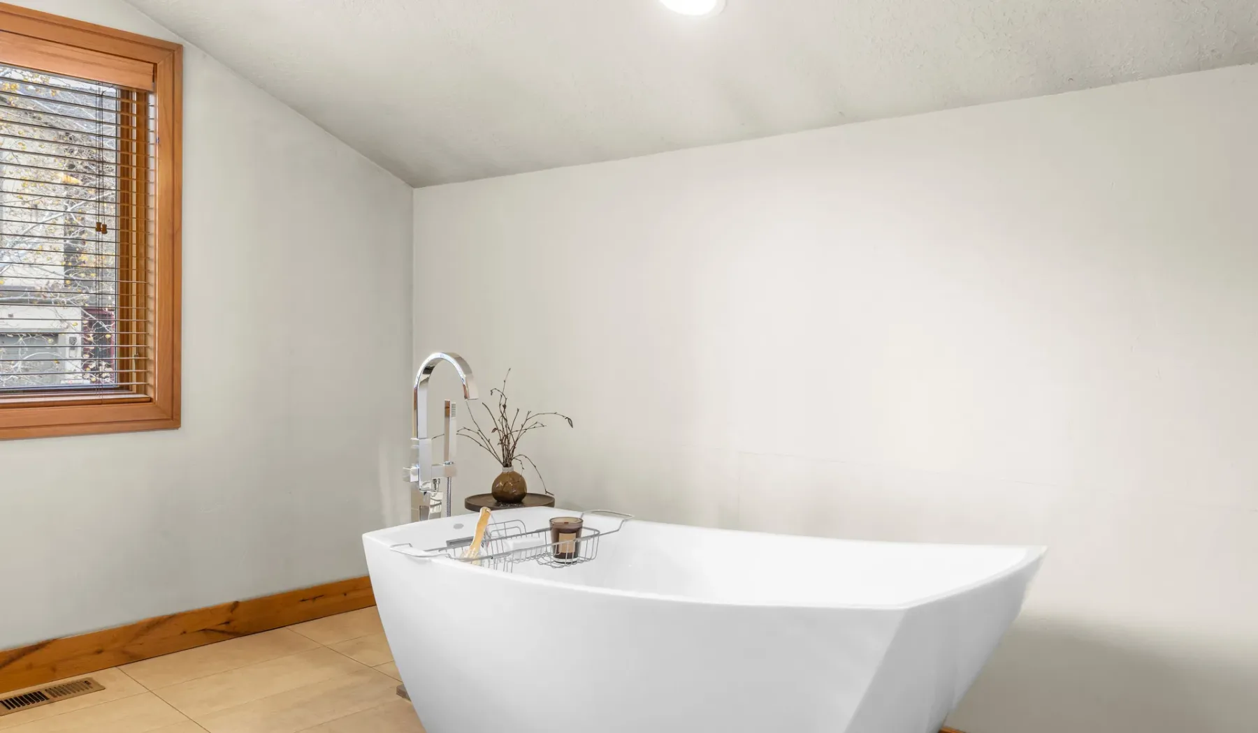 Un baño con una bañera exenta junto a una ventana.