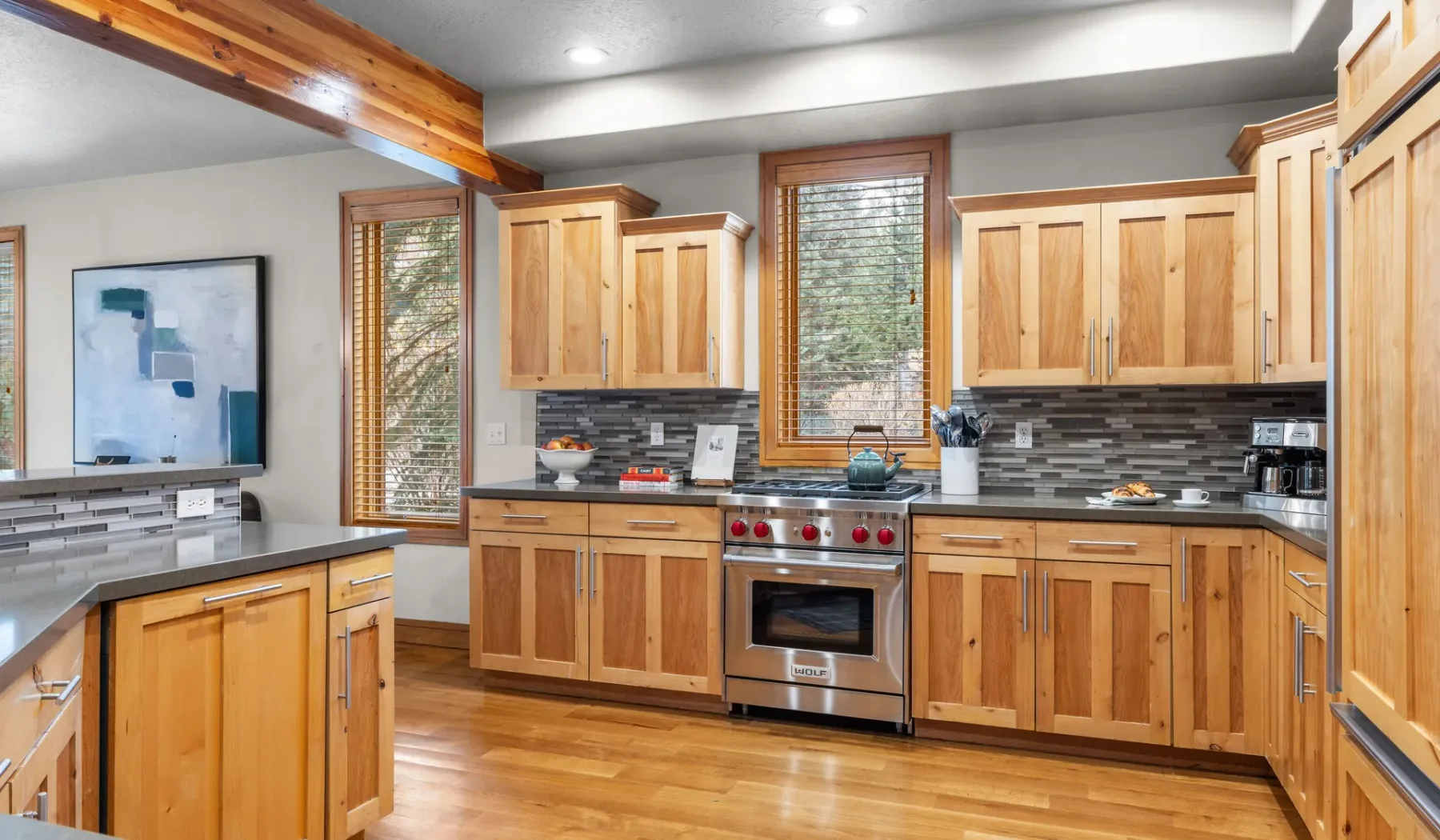 Una cocina con gabinetes de madera, electrodomésticos de acero inoxidable y un salpicadero de azulejos.
