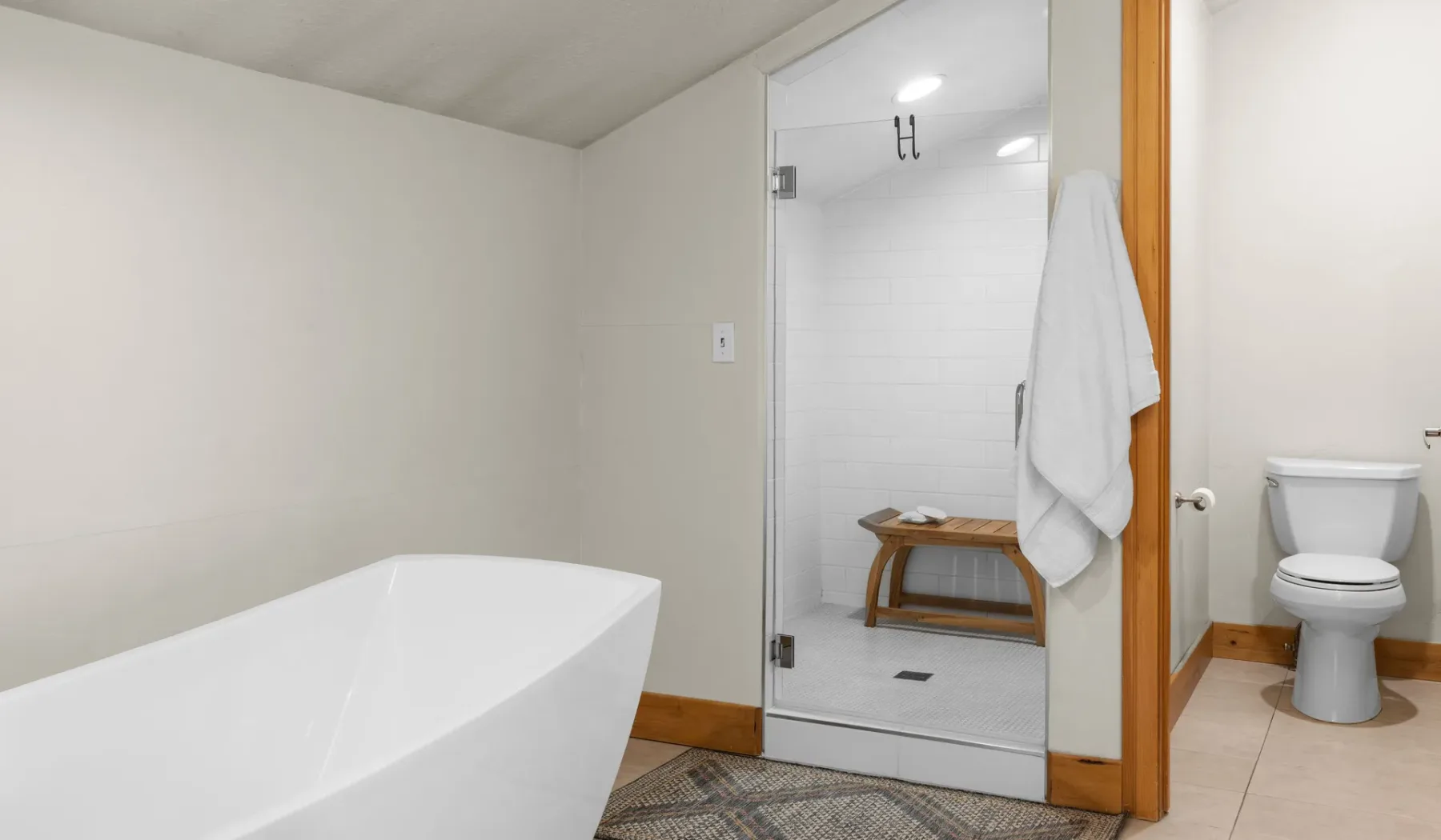 Un baño con bañera exenta, ducha de vidrio e inodoro.